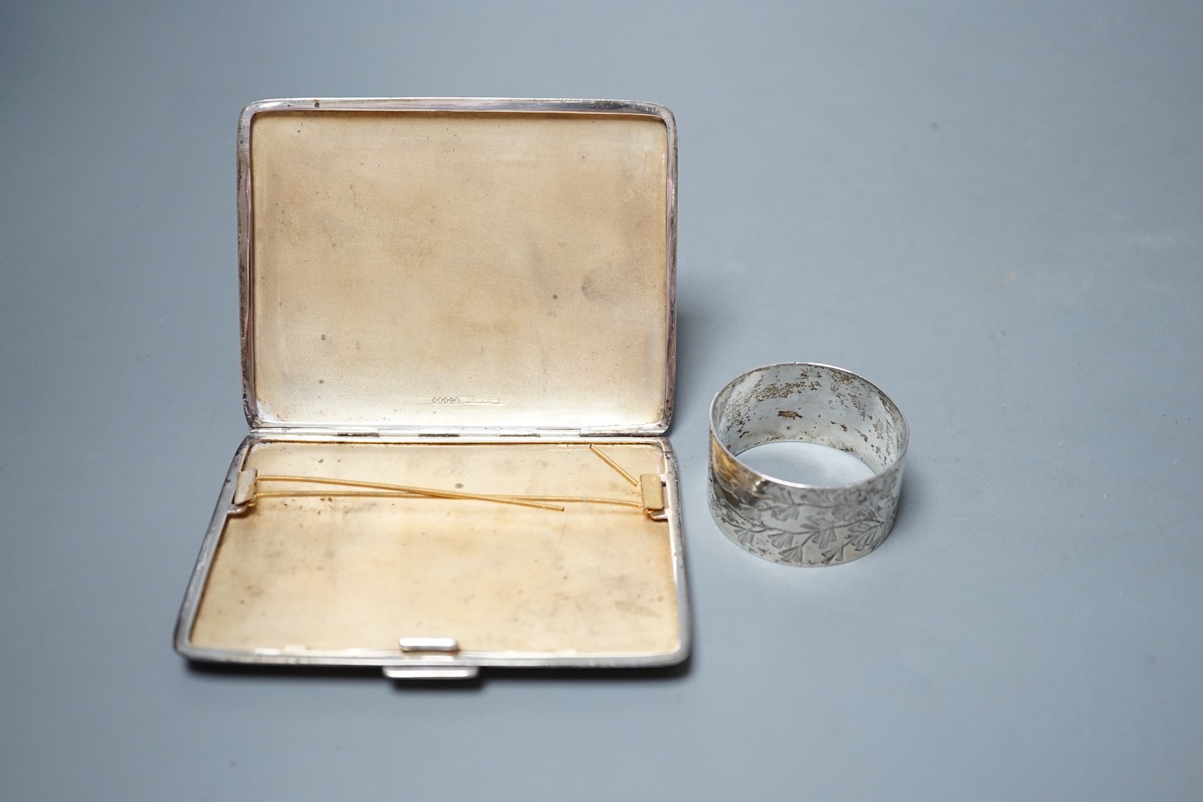 A silver cigarette case and a silver napkin ring.